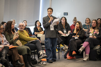 A person speaks to a room through a microphone.