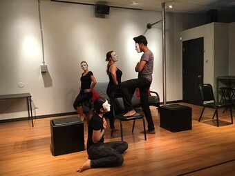 A group of actors rehearse in masks.