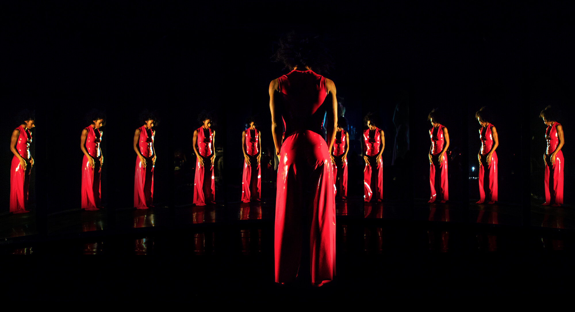 performer in a red dress in a mirror effect of multiple reflections