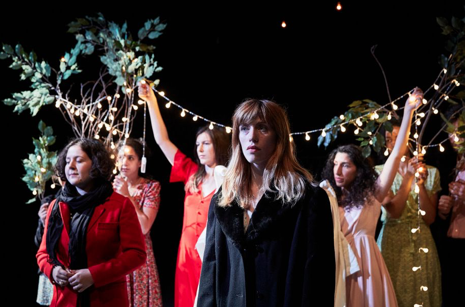 a group of women standing under fairy lights
