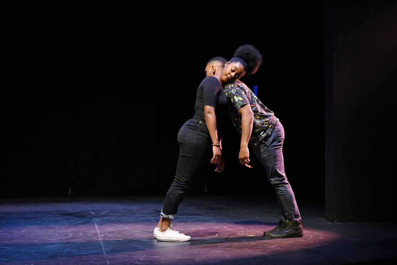 two performers embrace onstage