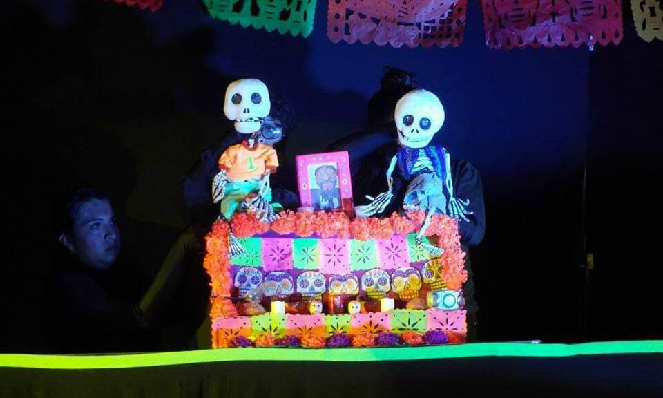 a puppeteer maneuvers two skeleton puppets