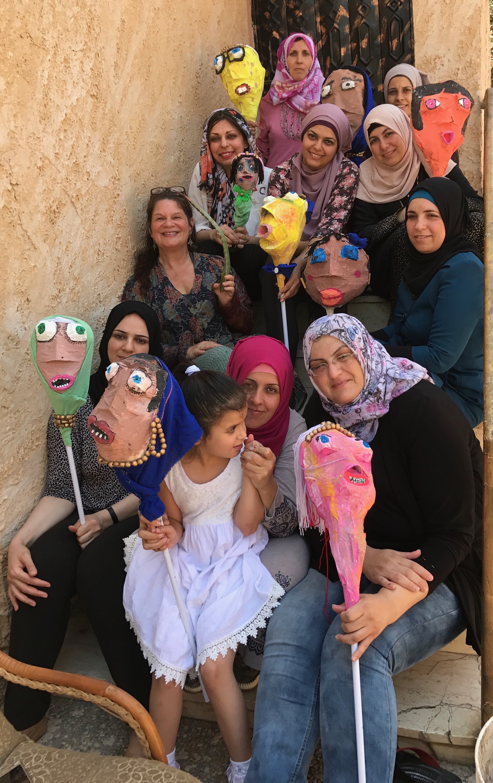 a group of smiling people holding puppets