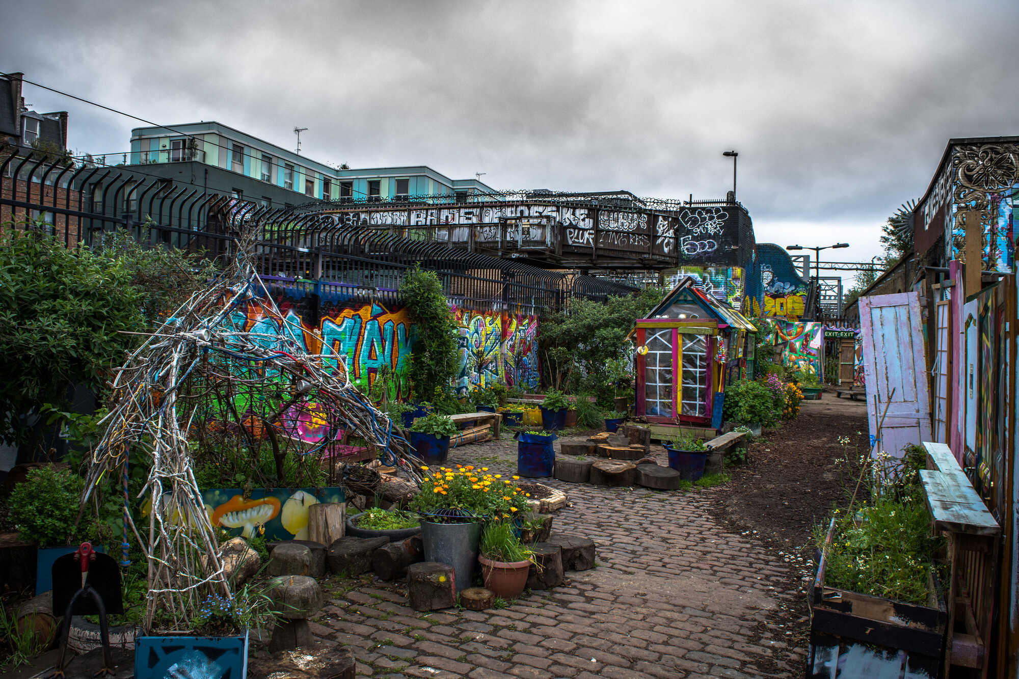 colorful community garden with graffiti on brick walls