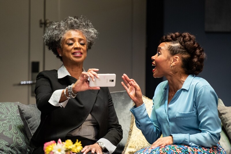two Black actresses take a selfie onstage