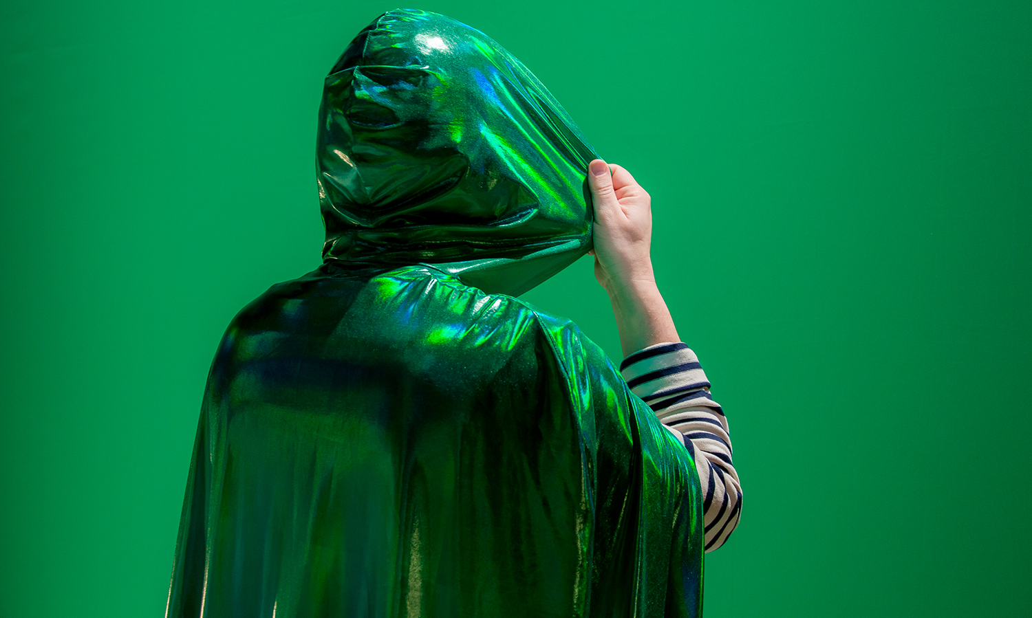 a hooded figure in green against a green background