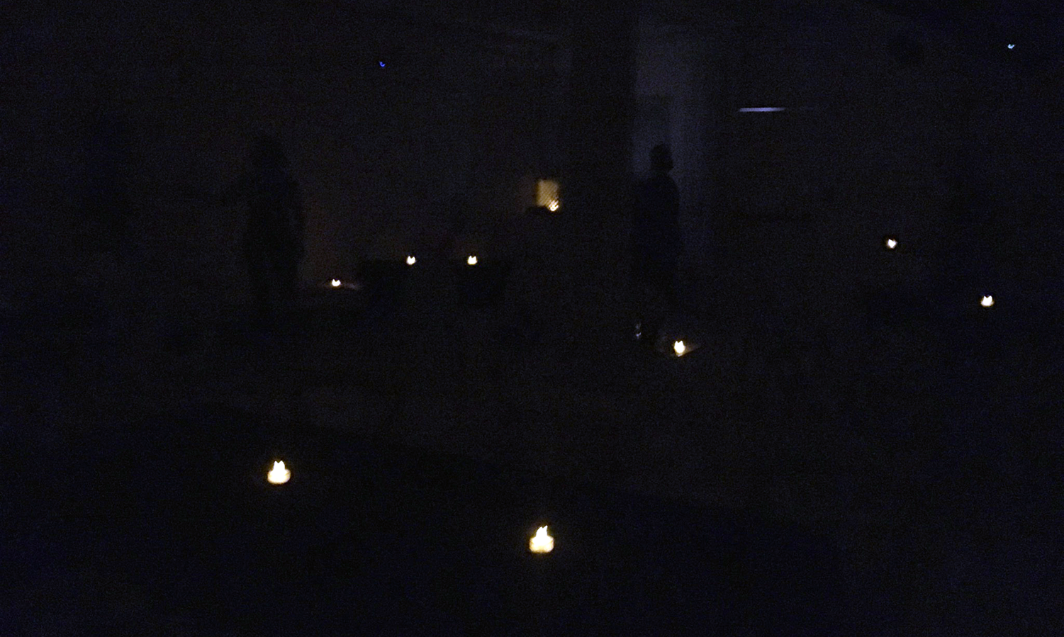 a dark room lit by small candles