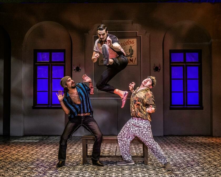 three actors onstage, one jumping up in the air.
