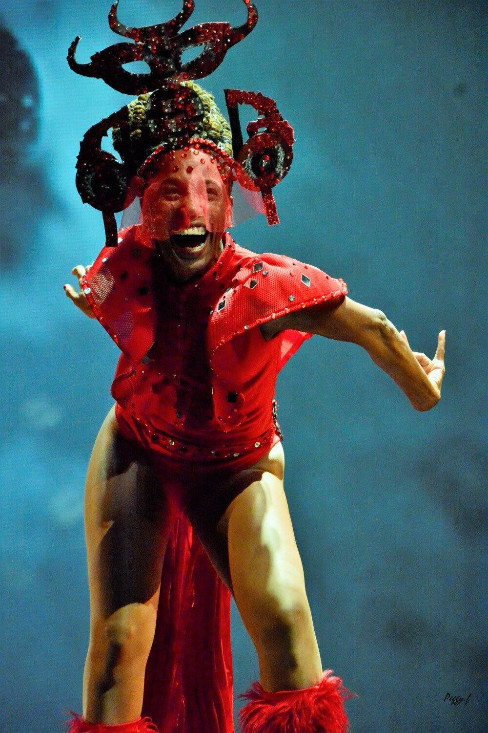 performer in red devil costume onstage.