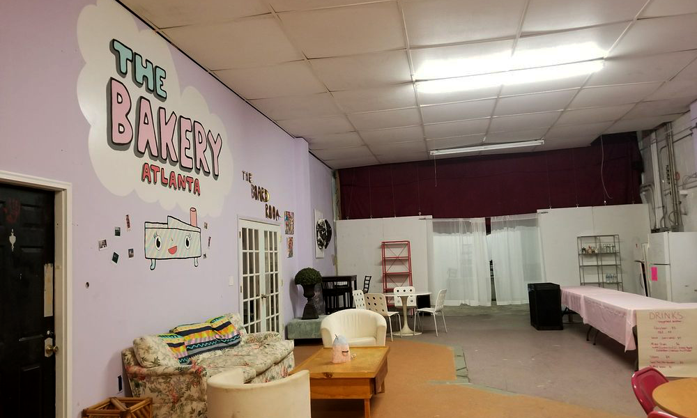 a large room with furniture and the mural "The Bakery Atlanta" on one wall
