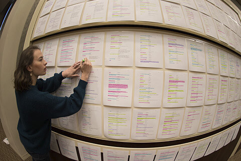 fisheye photo of a person standing at a wall with several papers attached to it