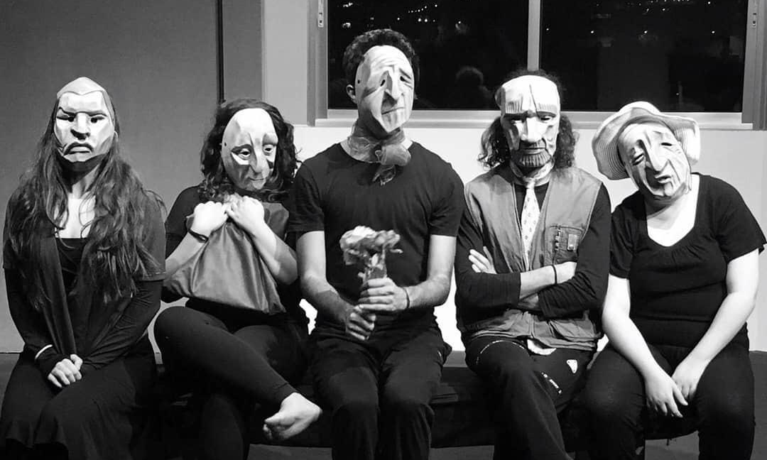 black and white photo of five seated people in masks