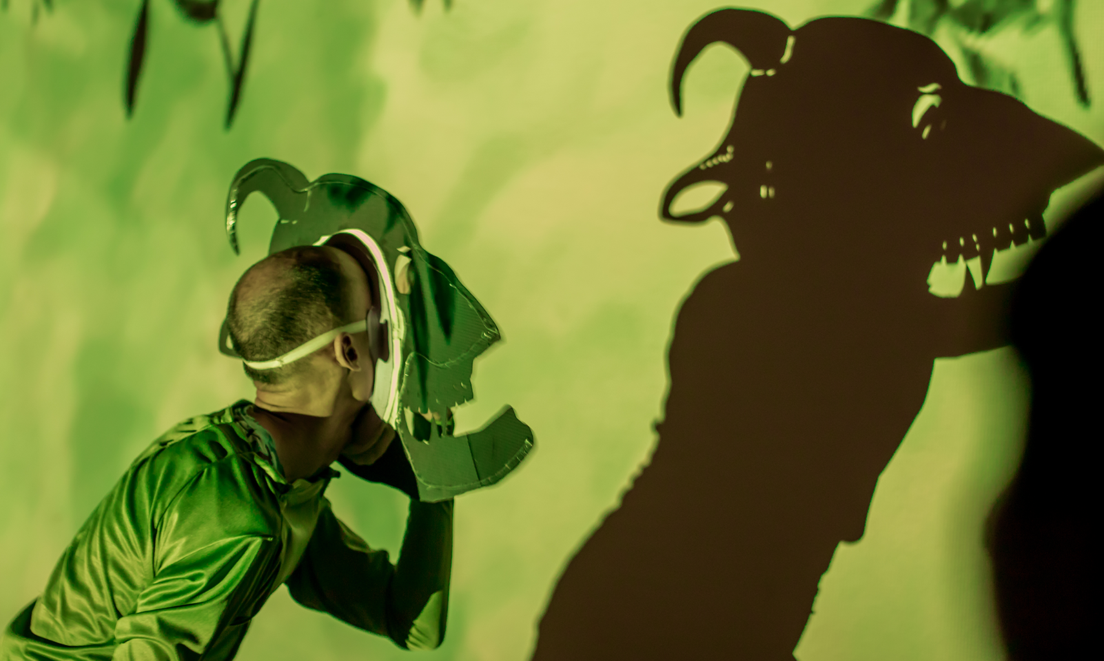 an actor onstage performing shadow puppetry