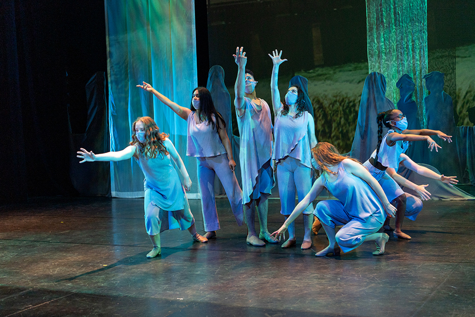 six performers on a stage with watery blue silks