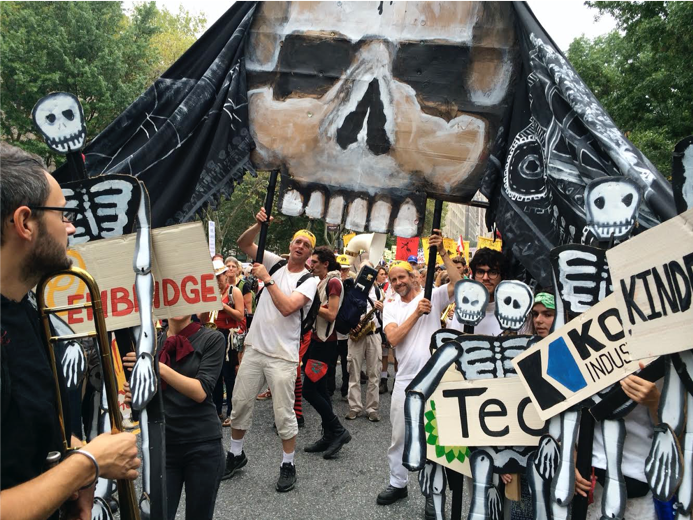 Bread and Puppet Theater protestors with a large skeleton puppet and signs at People's Climate March in New York City.