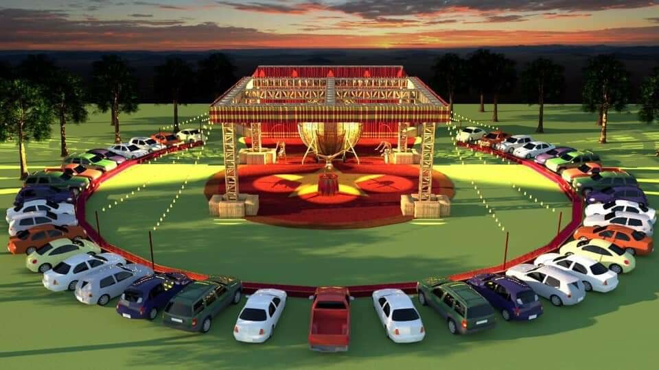 An image of an out door theatre with cars circling the stage. 