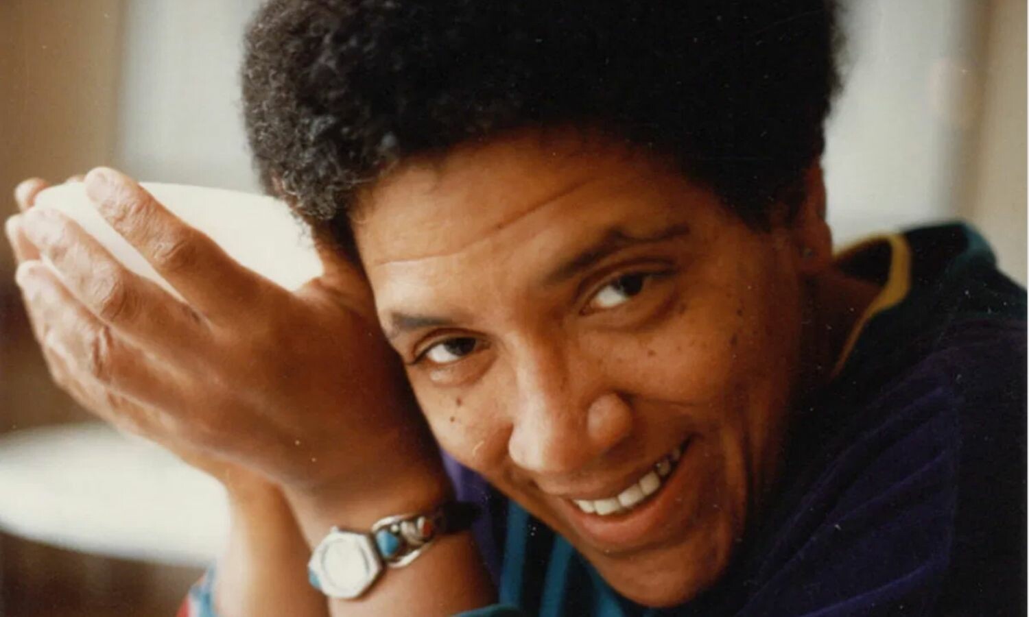 Audre Lorde holding a hollow white object.