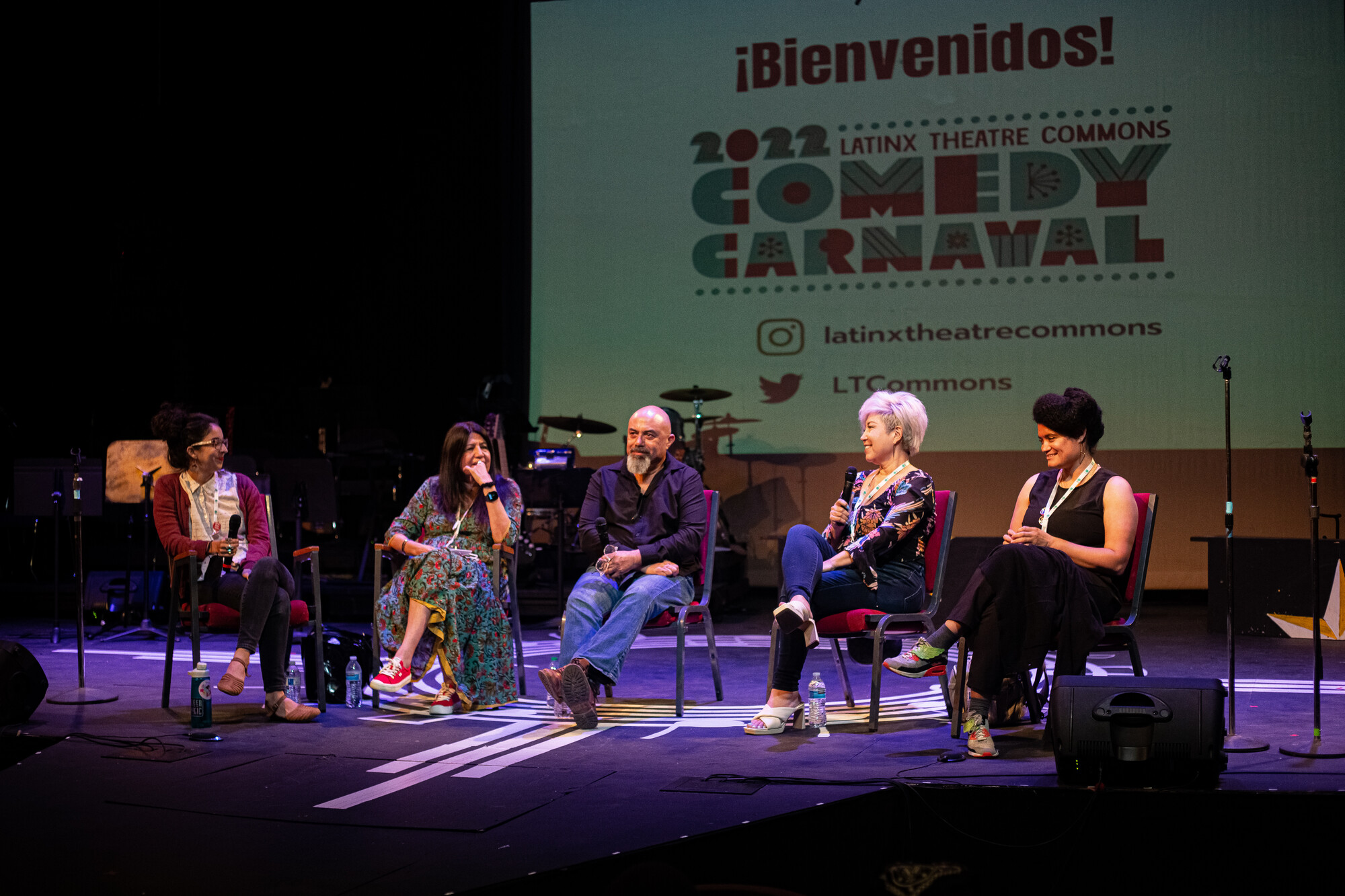 A panel of playwrights sitting on a stage answering questions. 