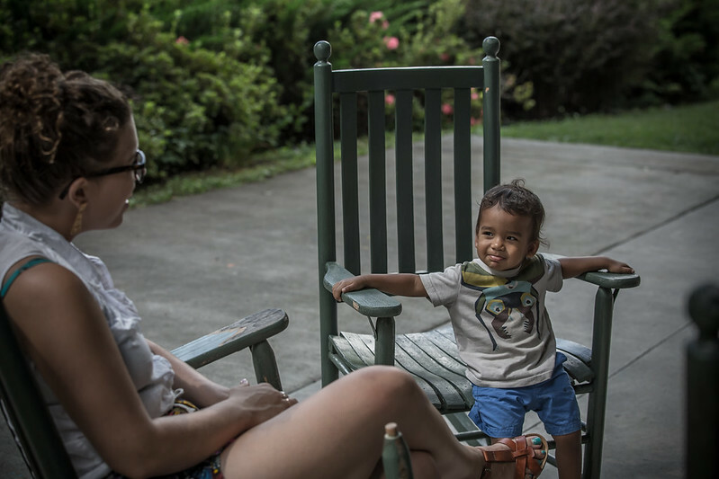 A mother and her son sitting together in rocking chairs on a porch.