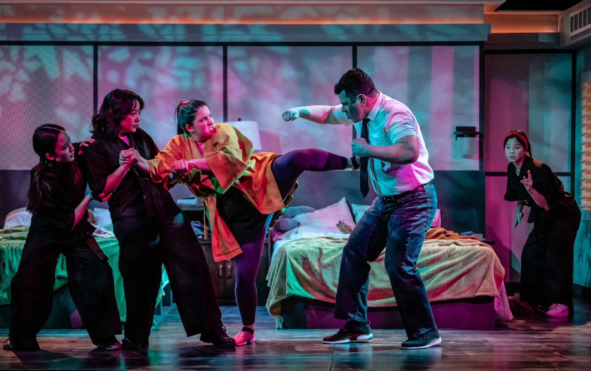 A group of actors perform a fight onstage.