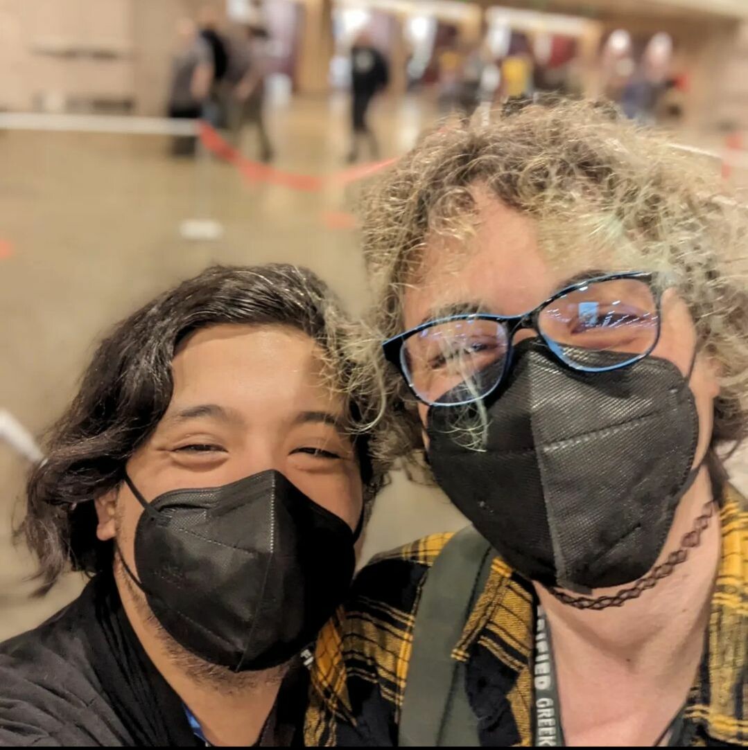 A selfie of two people wearing masks standing in an airport.