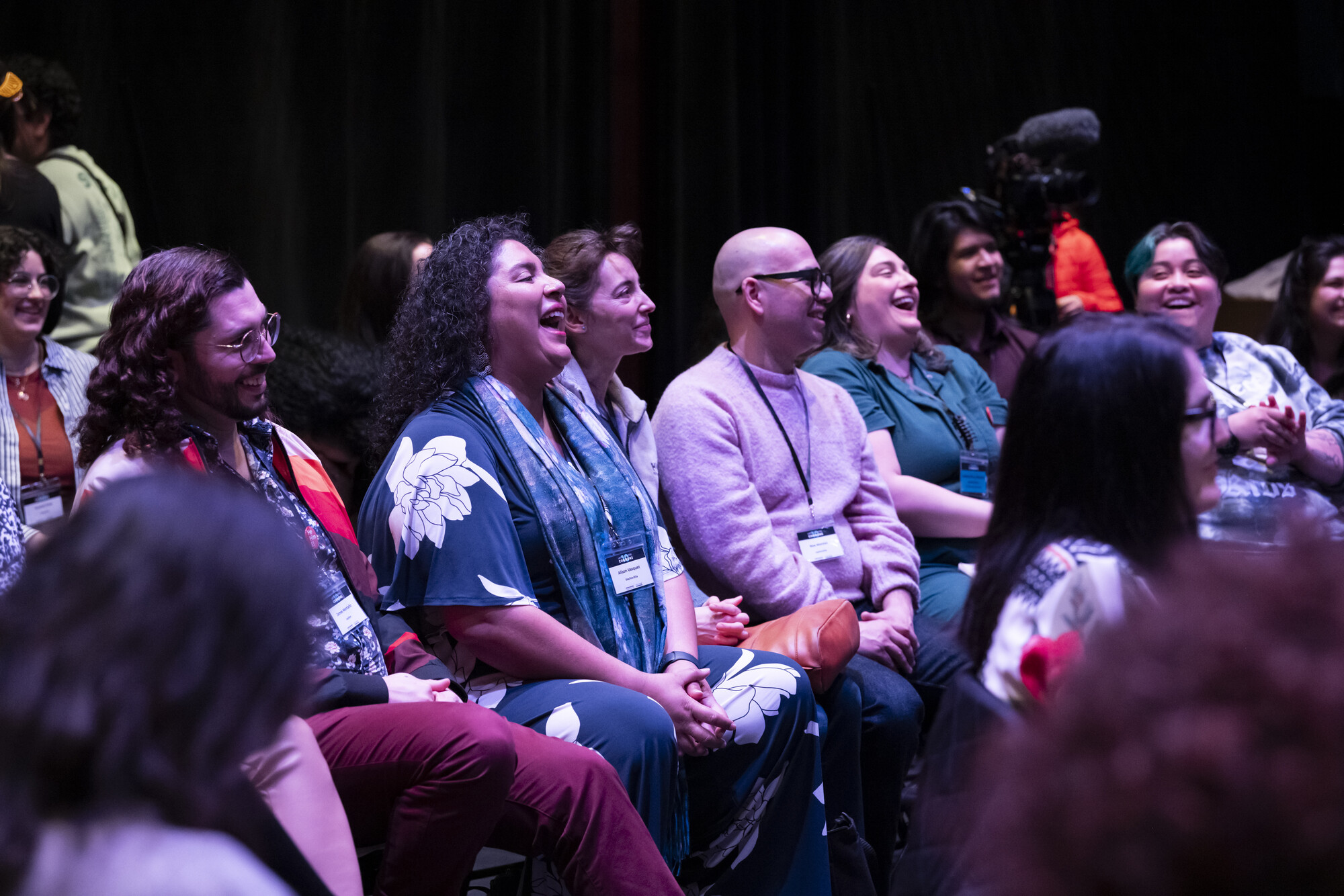 A group of people sit on chairs listening to a speaker.