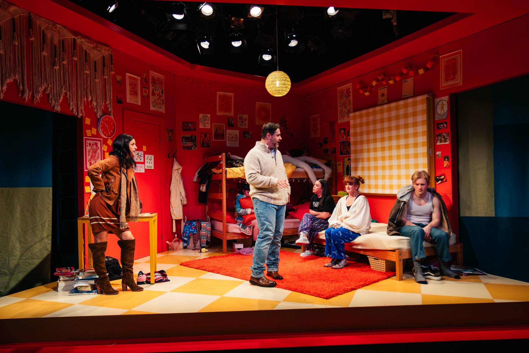 A group of performers perform in a brightly colored set.