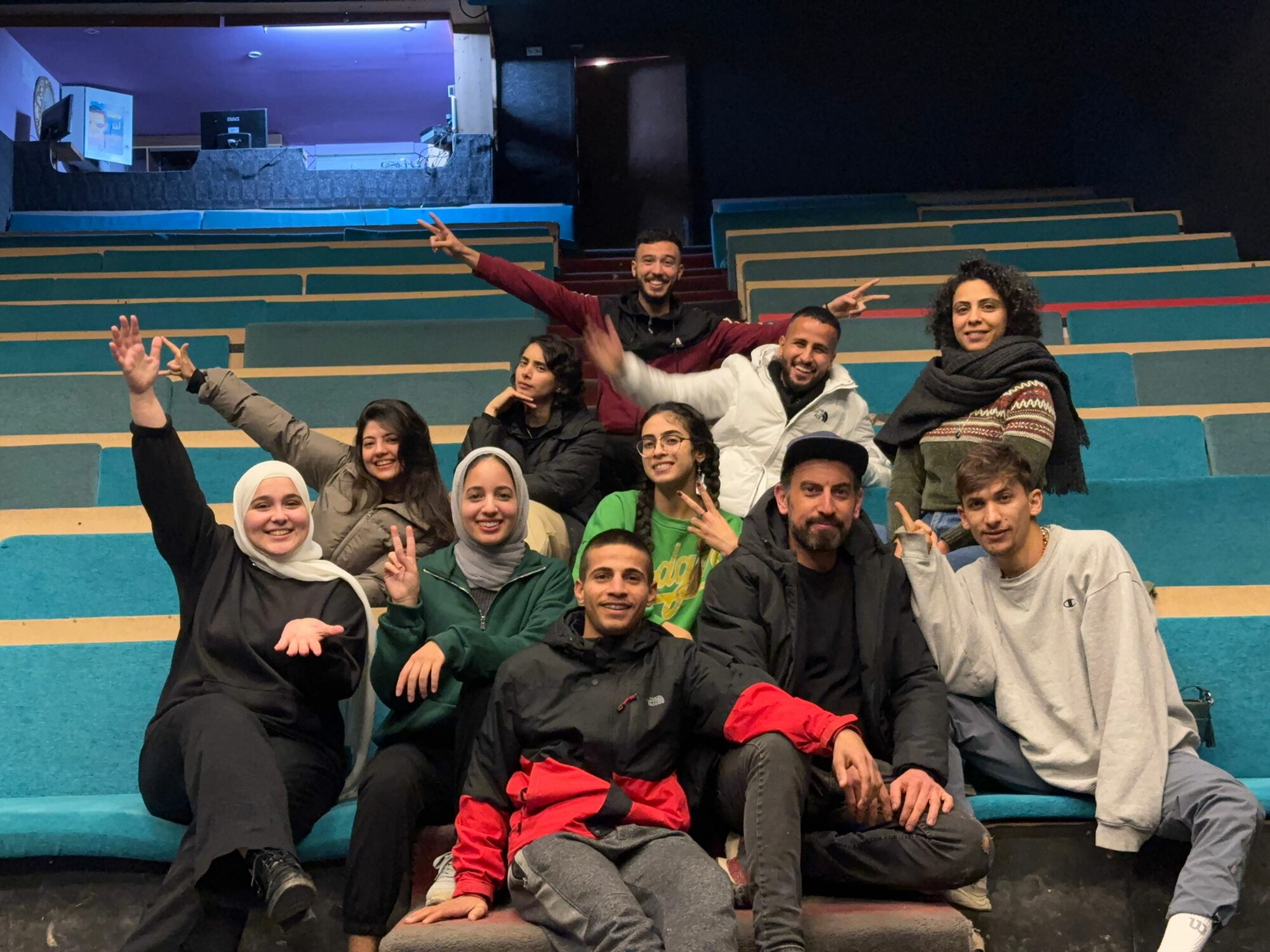 A photo of a group of students sitting in a Theatre.