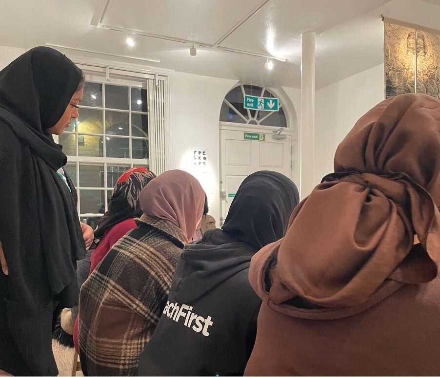 Four woman in hijabs sit while taking part in a workshop.