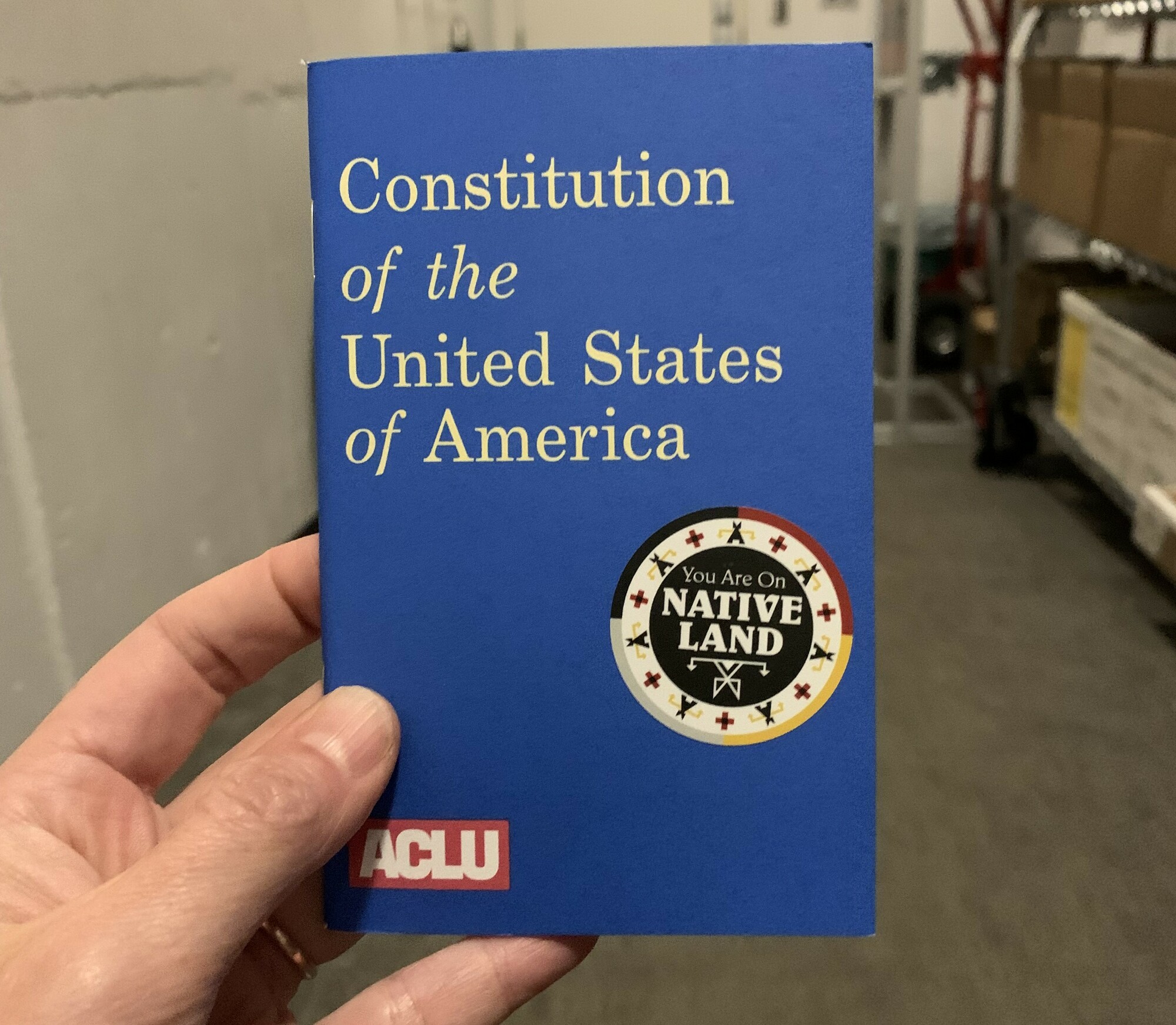 A copy of the constitution with a sticker reading You Are On Native Land.