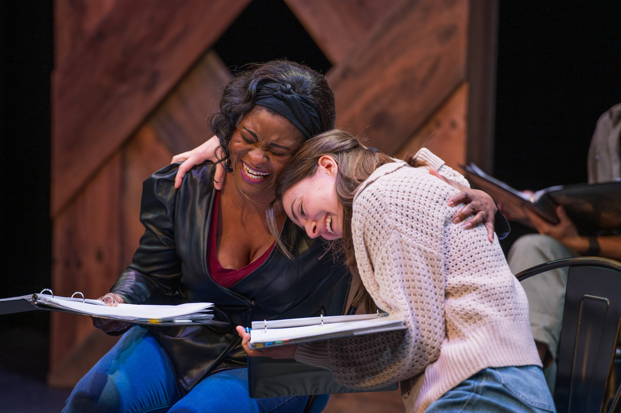 Two people embrace happily on stage. 