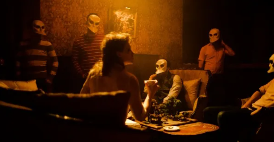 A group of people sitting in chairs and wearing white masks.