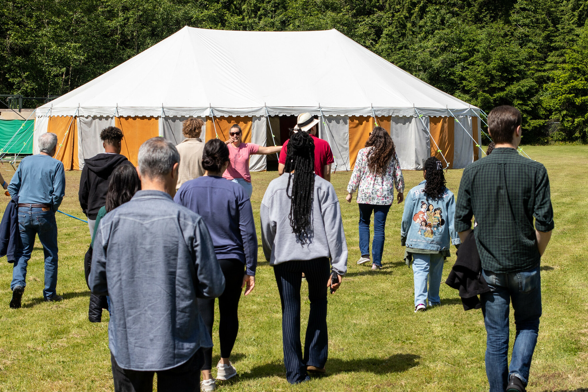 A crowd walks towards a large white tent.