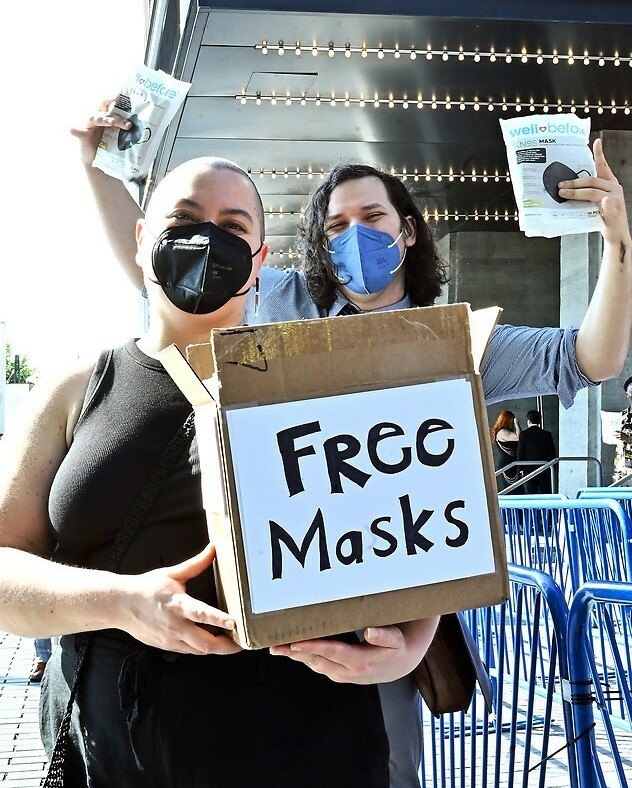 Two people holding a box that says "Free Masks".
