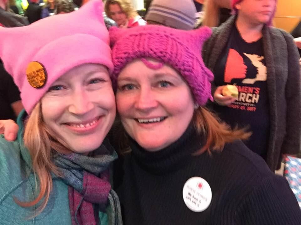Two women in pink hats taking a selfie. 