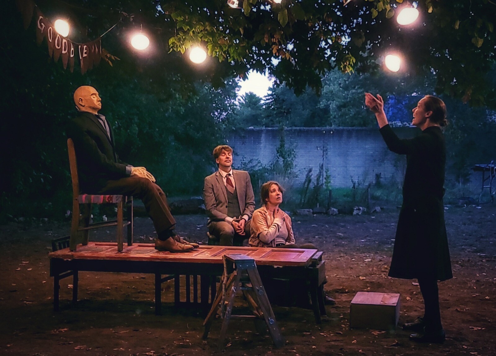 A group of people acting under a tree canopy.