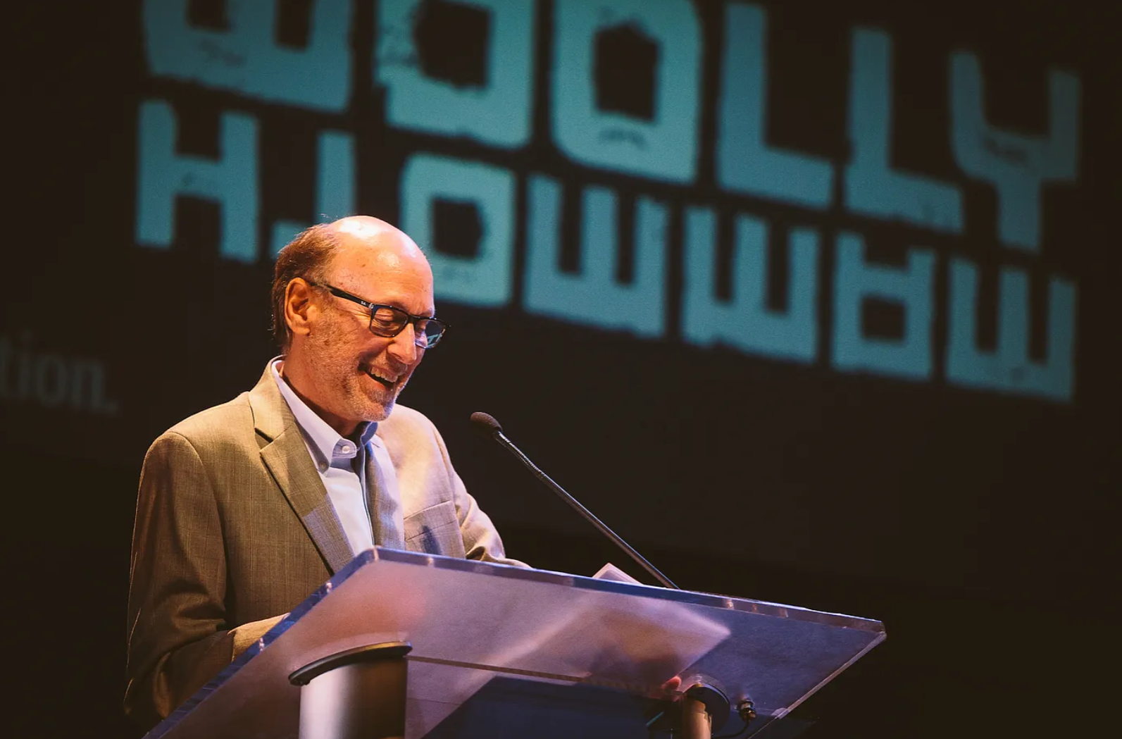 A older man speaking at a podium. 