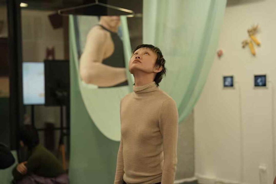 A person dressed in beige looking upwards. 