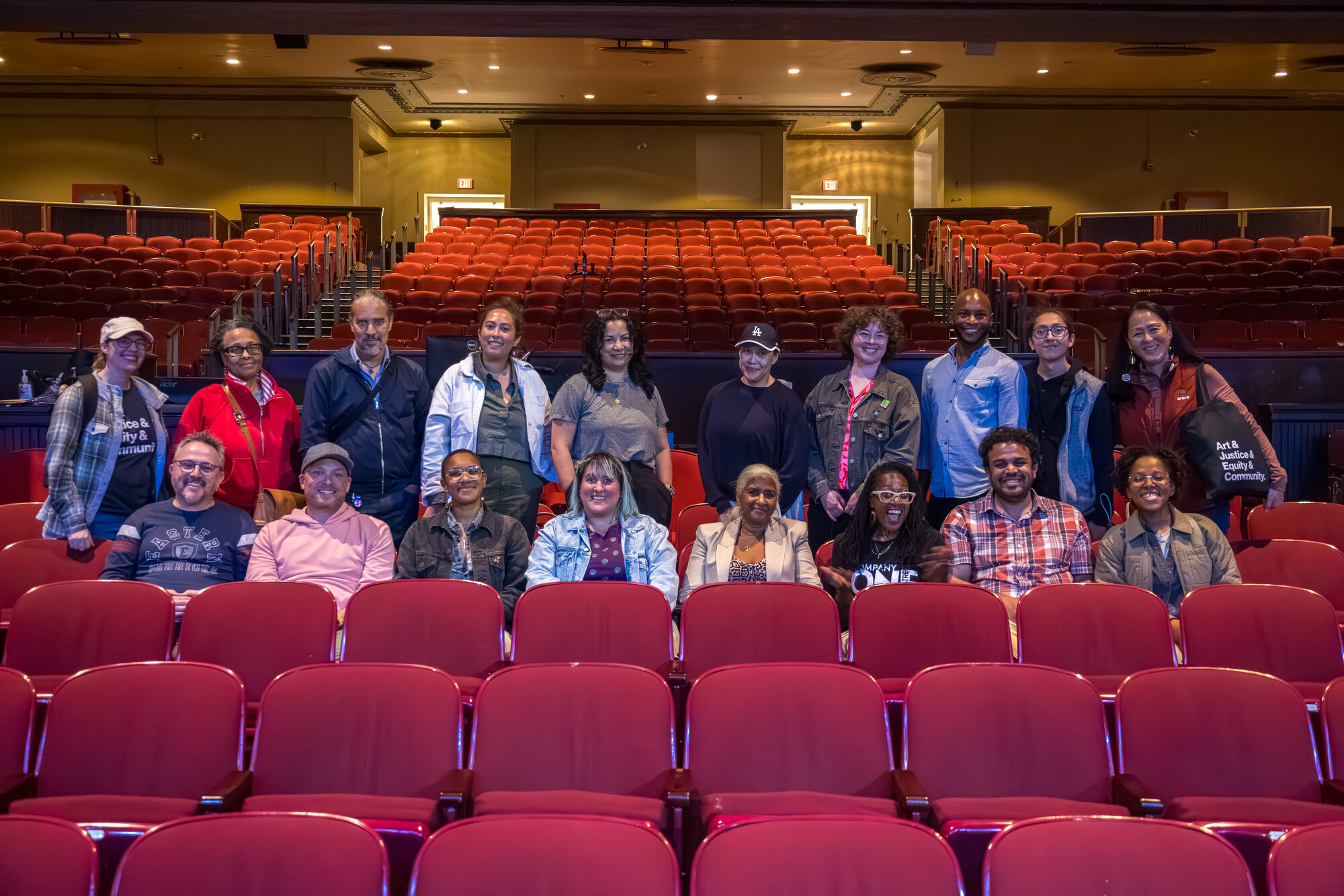 A group of people posing together in a theater audience.