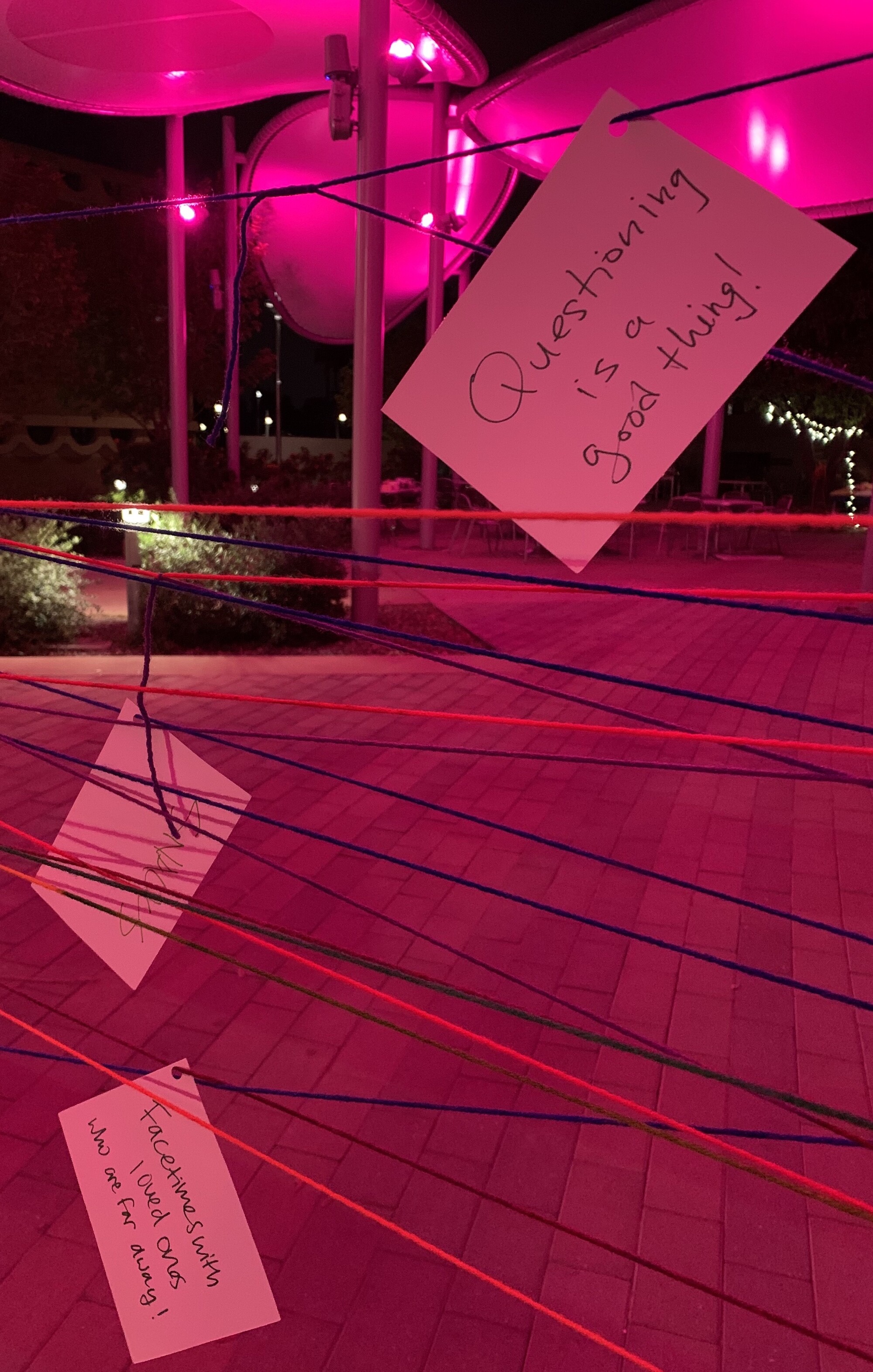A close up of some strings with notecards on them.