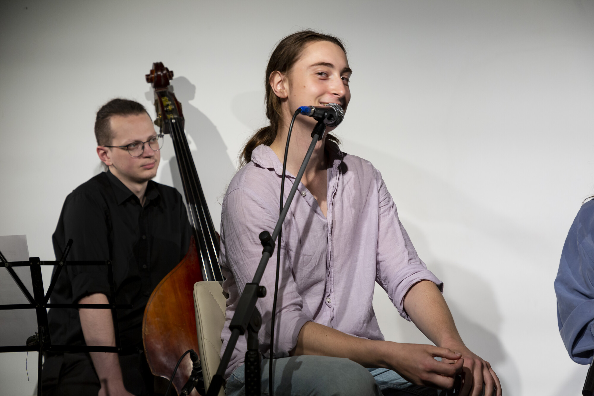 A person with a ponytail speaks into a microphone.