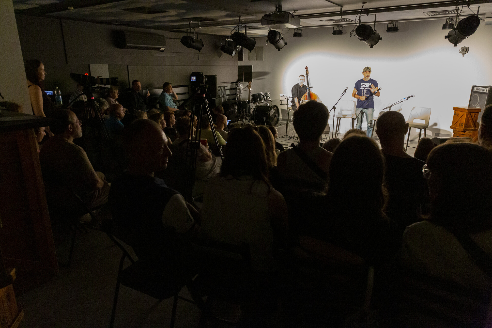 A small band plays onstage in front of an audience.