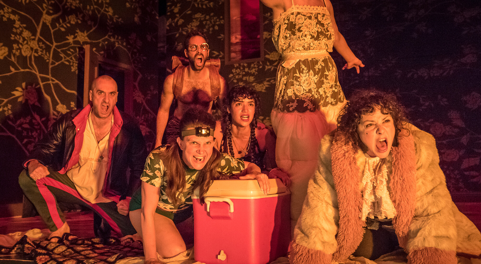 A group of people acting menacing in fire light.