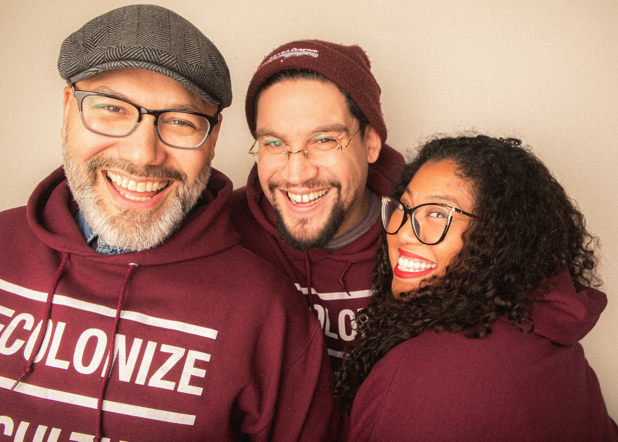 Three people smiling and embracing.