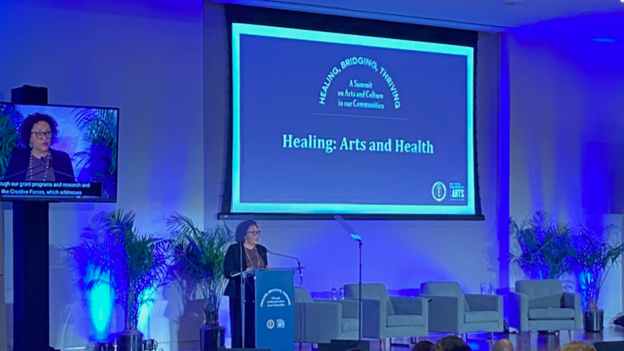 A woman on stage giving a presentation.
