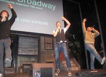 A group of men on stage singing and dancing.