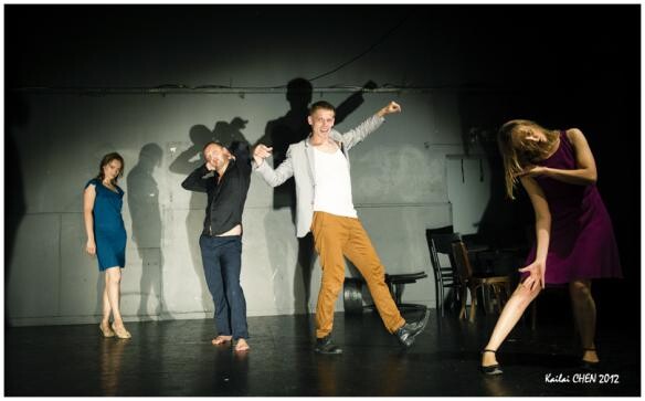 Actors on a black box stage.