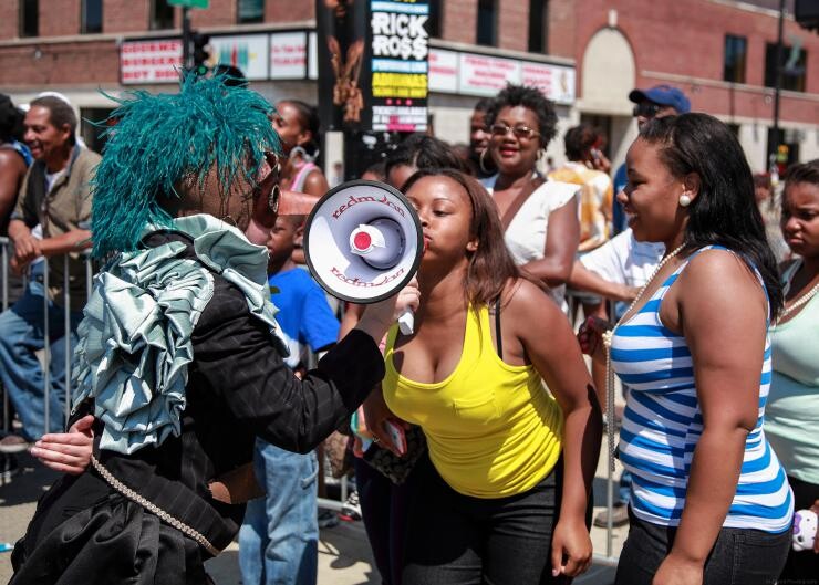 A person speaking into a mega phone at a rally.