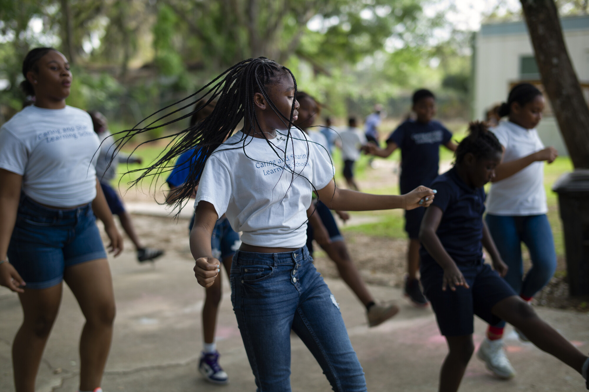 A group of kids dancing outdoors.
