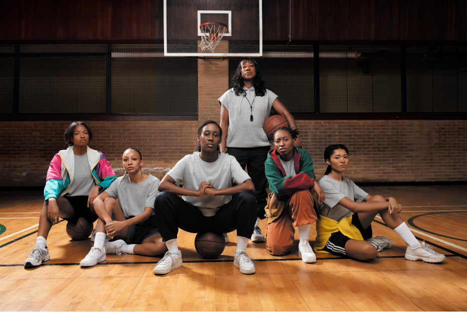 A basketball team posed for a photo on a court.